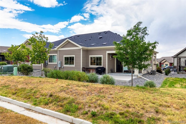 12673 Tamarac St, Thornton, CO 80602 - rear view of property featuring a patio, a lawn, and a shingled roof