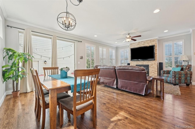 7902 E 49th Pl, Denver, CO 80238 - dining space with healthy amount of natural light, ornamental molding, a stone fireplace, wood finished floors, and a ceiling fan