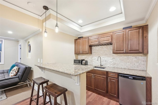7902 E 49th Pl, Denver, CO 80238 - kitchen featuring stainless steel appliances, a kitchen breakfast bar, light wood finished floors, crown molding, and a peninsula