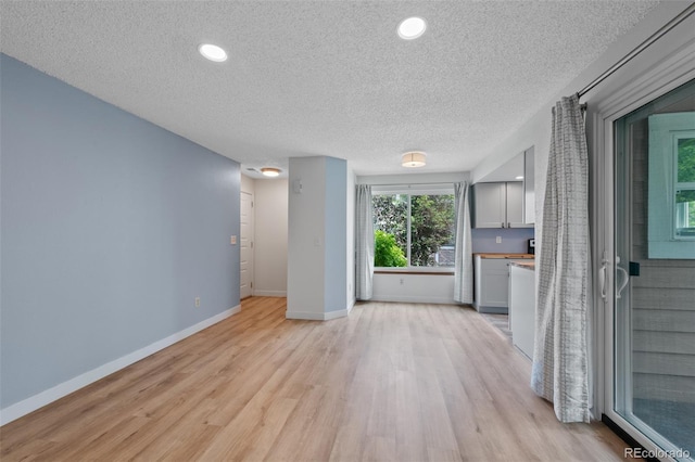 8378 S Upham Way Unit B205, Littleton, CO 80128 - unfurnished living room with a textured ceiling, light wood-style floors, baseboards, and recessed lighting