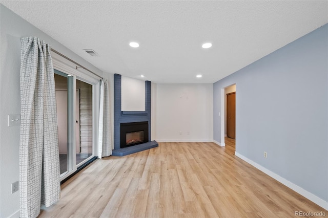8378 S Upham Way Unit B205, Littleton, CO 80128 - unfurnished living room with light wood-style flooring, a large fireplace, baseboards, and recessed lighting