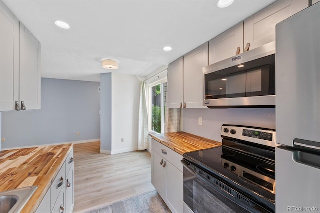 8378 S Upham Way Unit B205, Littleton, CO 80128 - kitchen featuring wooden counters, stainless steel appliances, baseboards, light wood-type flooring, and recessed lighting