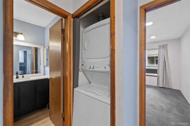 8378 S Upham Way Unit B205, Littleton, CO 80128 - laundry room featuring stacked washer / drying machine, a textured ceiling, and recessed lighting