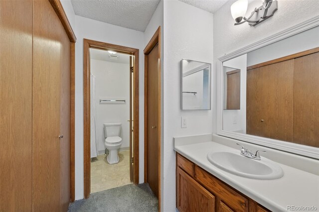 8378 S Upham Way Unit B205, Littleton, CO 80128 - bathroom with vanity, toilet, and a textured ceiling