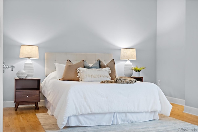 bedroom featuring wood finished floors and baseboards