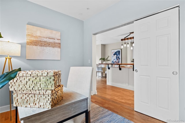 living area with baseboards and wood finished floors