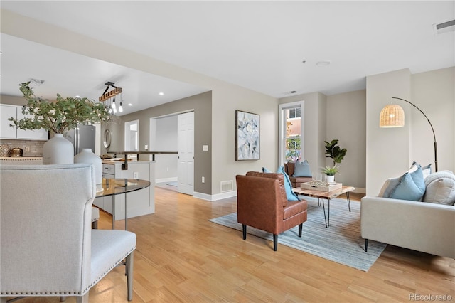 living area with light wood-style flooring, recessed lighting, baseboards, and visible vents