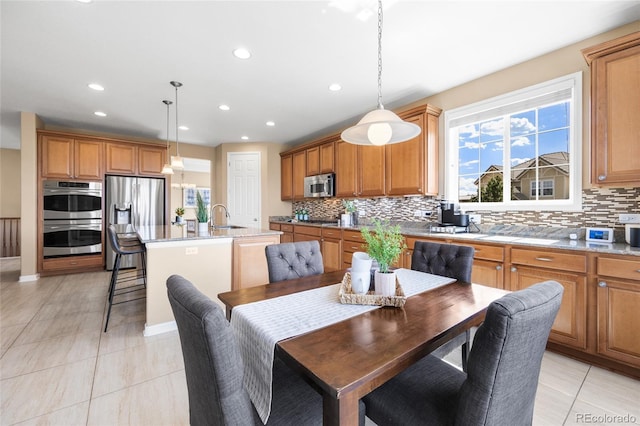 tiled dining room featuring sink and a wealth of natural light