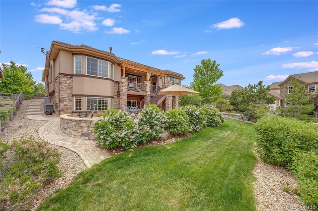 back of property with a lawn and a patio area