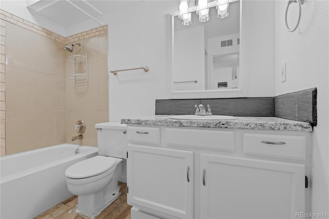 full bathroom featuring vanity, tasteful backsplash, toilet, and tiled shower / bath