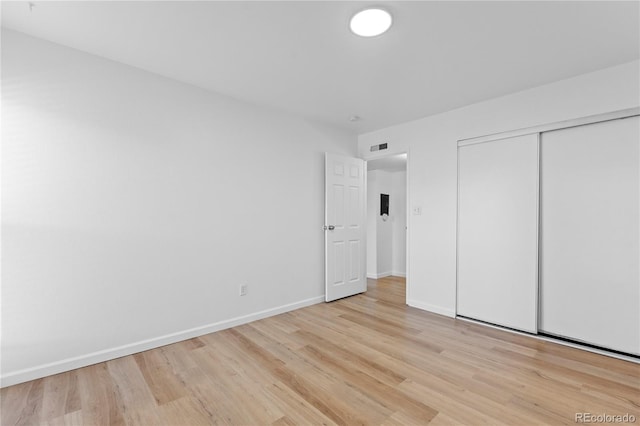 unfurnished bedroom featuring light wood-type flooring and a closet