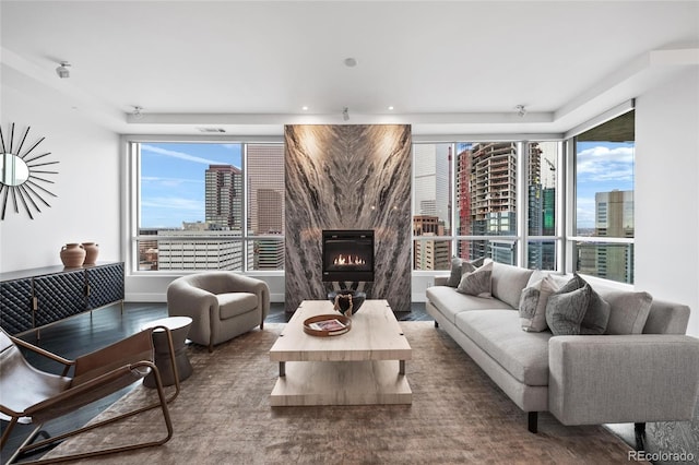 living room featuring visible vents, a fireplace, baseboards, and a city view