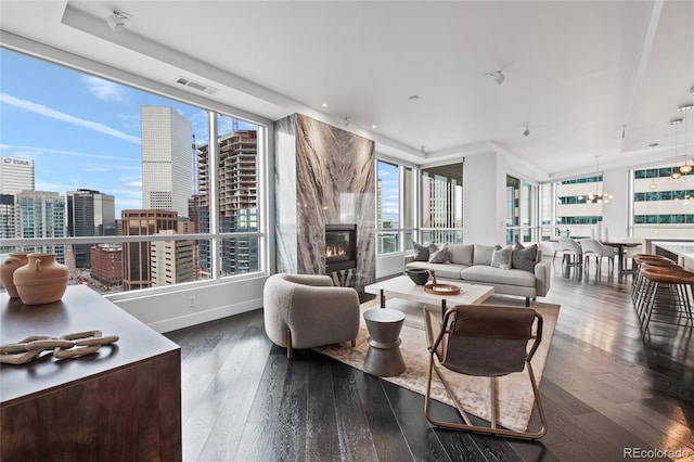 living area featuring a city view, wood-type flooring, visible vents, a high end fireplace, and baseboards