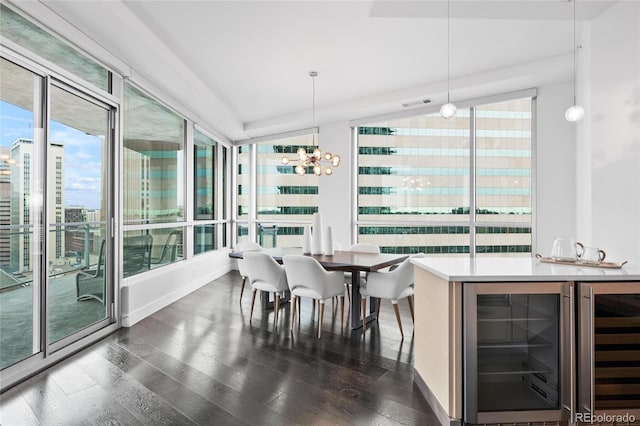 dining area featuring lofted ceiling, dark wood-style floors, wine cooler, and an inviting chandelier