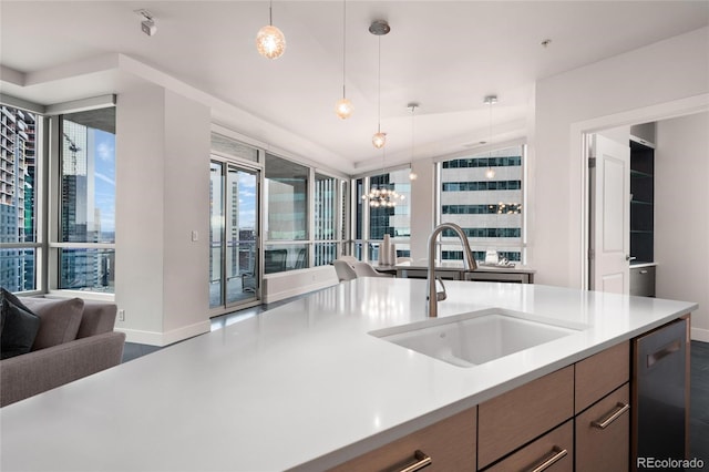 kitchen with dishwasher, open floor plan, an inviting chandelier, light countertops, and a sink