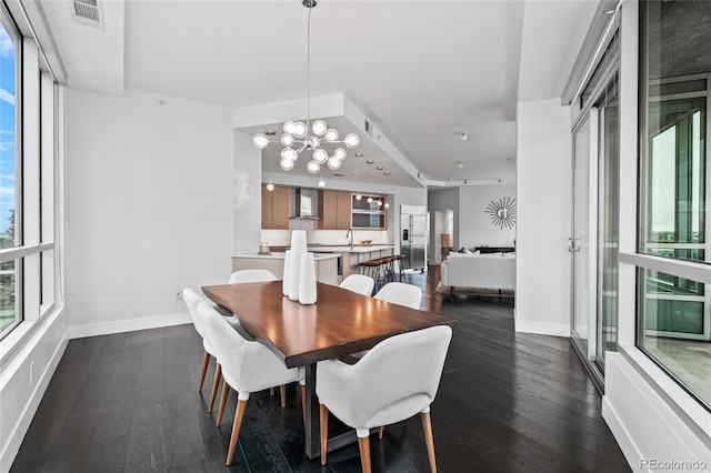 dining space with a notable chandelier, dark wood-type flooring, visible vents, and baseboards