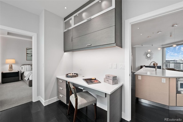 office area with dark wood-style floors, recessed lighting, a sink, and baseboards