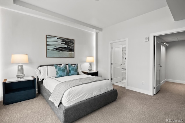 carpeted bedroom with connected bathroom and baseboards