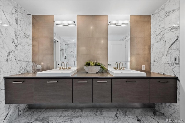 bathroom featuring stone wall, a sink, and tile walls