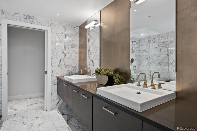 full bath featuring a sink, marble finish floor, double vanity, and tile walls