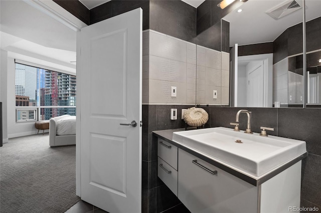 bathroom featuring vanity, visible vents, and tile walls