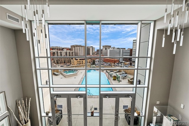 interior details with a view of city, french doors, and visible vents