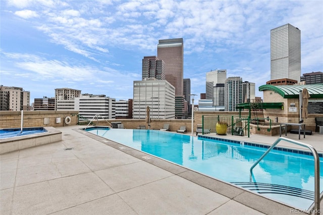 community pool featuring a patio area and a city view