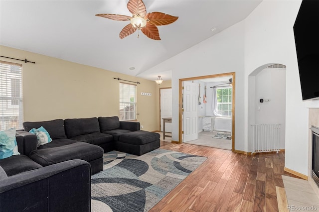 16257 E 105th Cir, Commerce City, CO 80022 - living room with radiator heating unit, ceiling fan, light wood finished floors, arched walkways, and baseboards