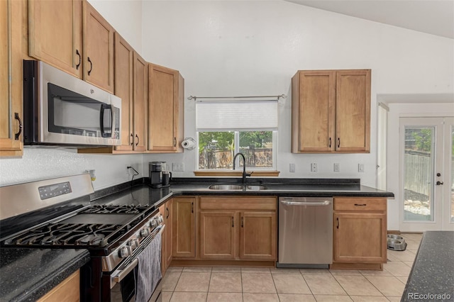 16257 E 105th Cir, Commerce City, CO 80022 - kitchen with appliances with stainless steel finishes, light tile patterned floors, a sink, plenty of natural light, and high vaulted ceiling