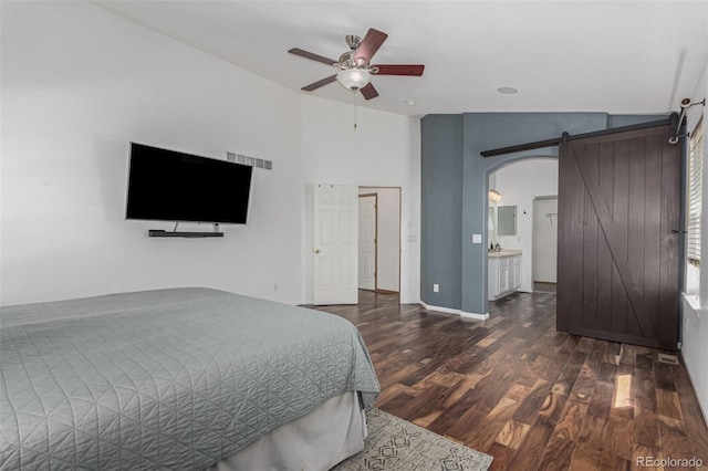 16257 E 105th Cir, Commerce City, CO 80022 - bedroom featuring a barn door, arched walkways, wood finished floors, ceiling fan, and lofted ceiling