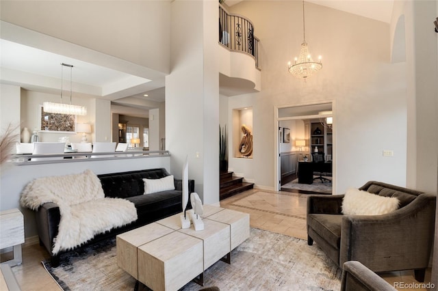 living room featuring a raised ceiling, a towering ceiling, and an inviting chandelier