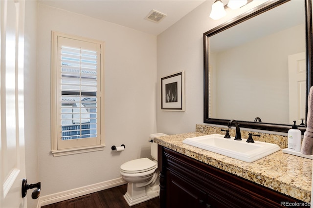 bathroom with vanity, toilet, and wood-type flooring