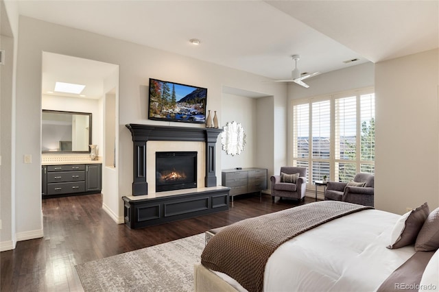 bedroom with ensuite bathroom and dark hardwood / wood-style floors