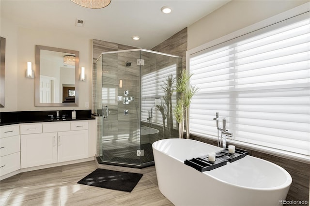 bathroom featuring hardwood / wood-style flooring, vanity, and shower with separate bathtub