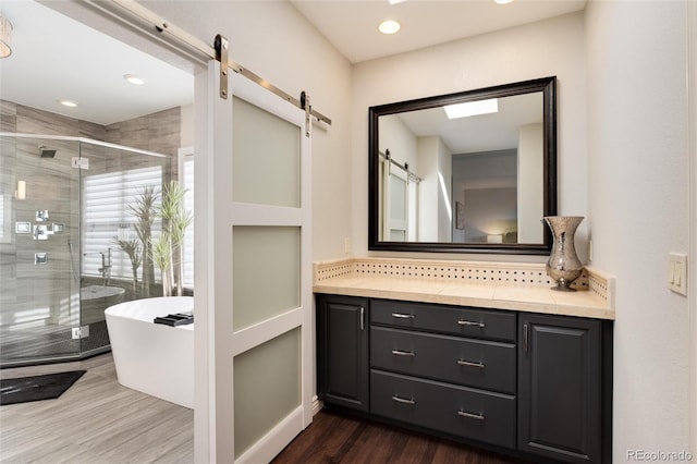 bathroom with tasteful backsplash, wood-type flooring, shower with separate bathtub, and vanity