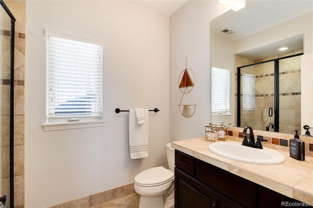 bathroom with vanity, a wealth of natural light, toilet, and walk in shower