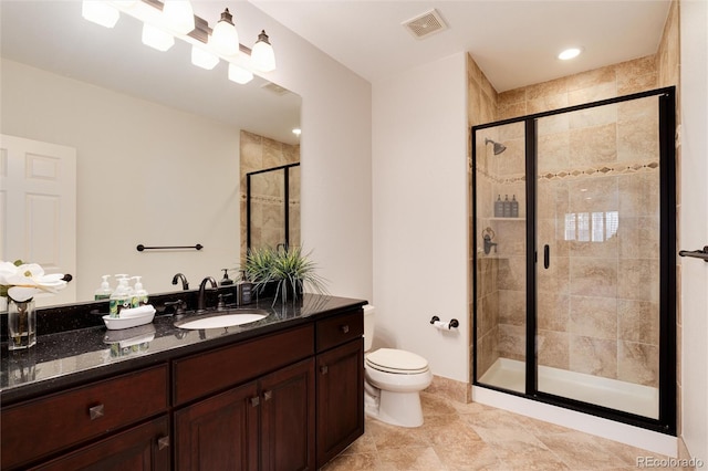 bathroom with vanity, toilet, and a shower with door