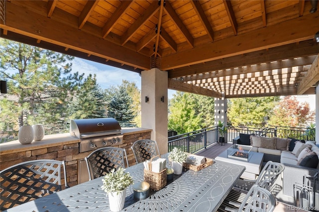 view of patio / terrace with an outdoor kitchen, area for grilling, and an outdoor living space with a fire pit