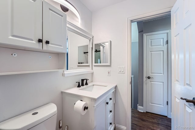 bathroom featuring toilet, hardwood / wood-style floors, and vanity