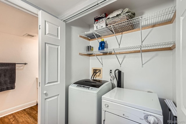 laundry area with dark hardwood / wood-style flooring and washing machine and clothes dryer