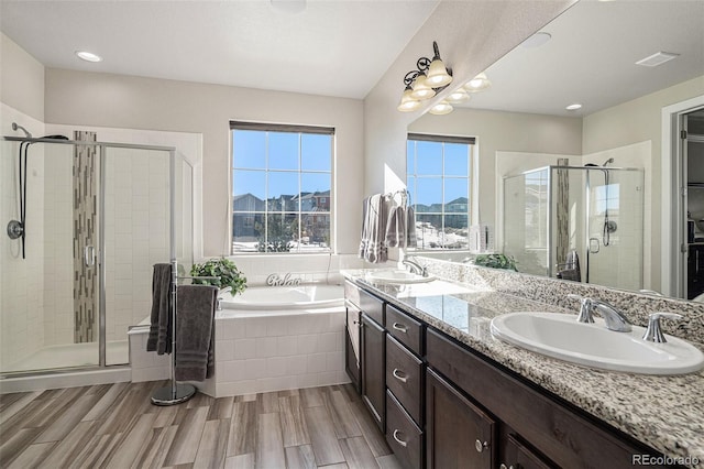 bathroom featuring separate shower and tub, hardwood / wood-style flooring, and vanity