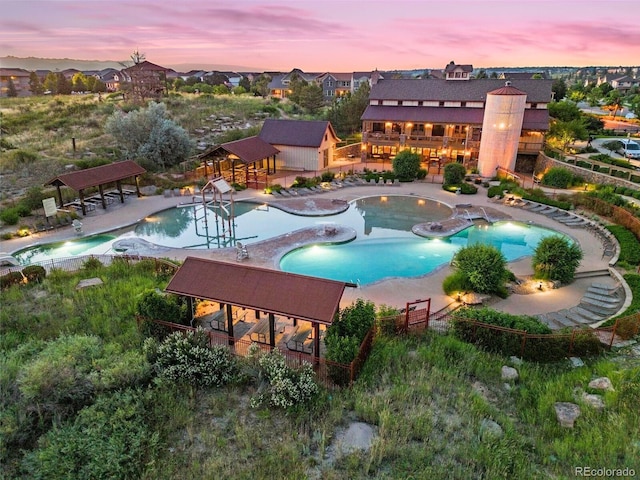 pool at dusk with a gazebo and a patio