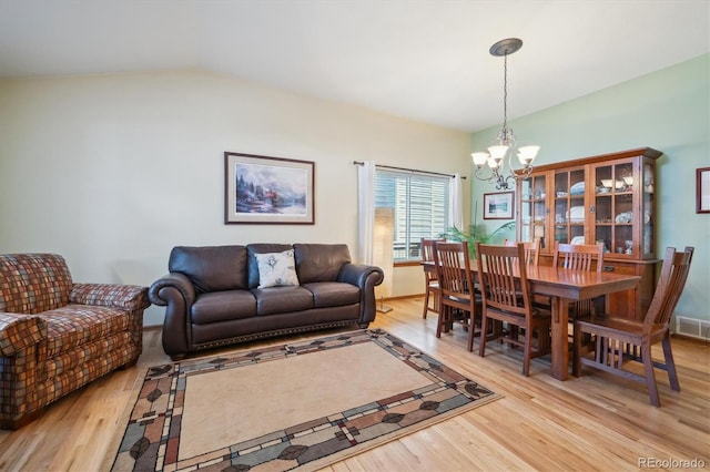 living area featuring a chandelier, light wood-style flooring, and visible vents