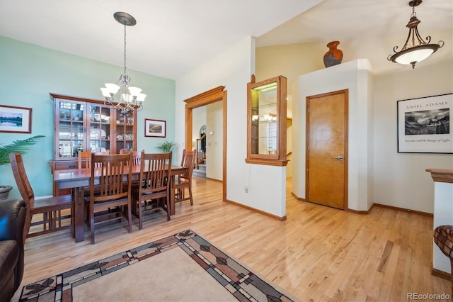 dining room with baseboards, light wood finished floors, and an inviting chandelier