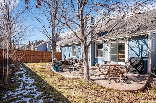 rear view of house with a fenced backyard and a patio