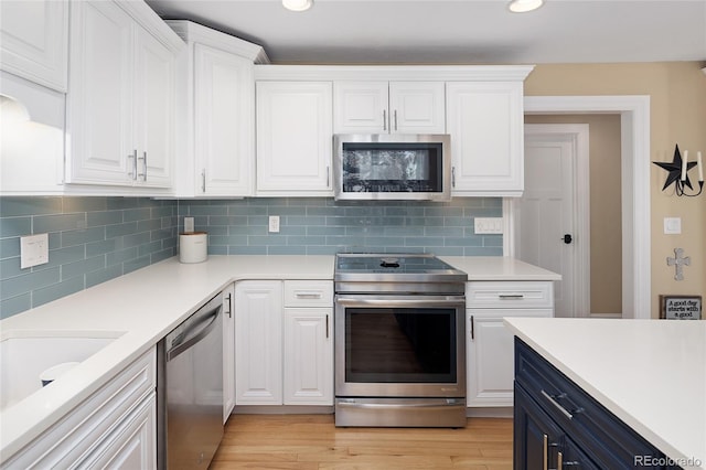 kitchen with stainless steel appliances, white cabinets, and light countertops