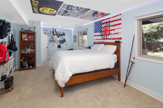 bedroom featuring light carpet and baseboards