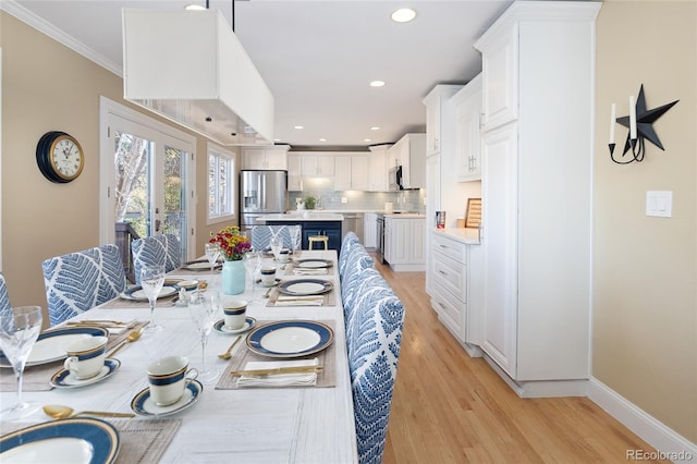 dining space featuring recessed lighting, baseboards, crown molding, and light wood-style floors