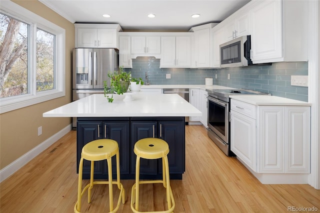 kitchen with white cabinetry, a breakfast bar area, and appliances with stainless steel finishes