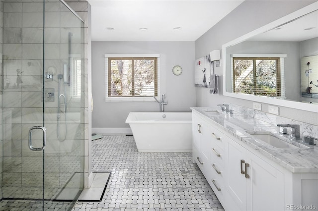 bathroom featuring a soaking tub, plenty of natural light, a shower stall, and a sink